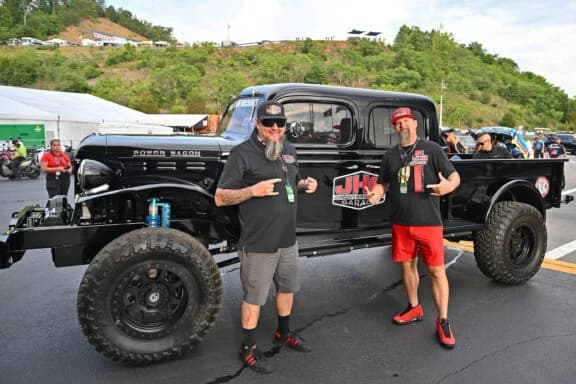 Two attendees beside the black VDM Power Wagon with JHG door branding at Bristol