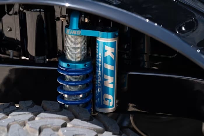 Blue King coilover and reservoir beneath SYNISTA’s front fender