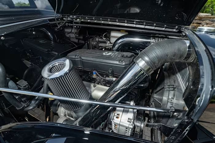 Open engine bay with polished intake piping and a large cone air filter — photo 11 of 23
