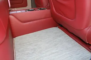 Rear footwell with light carpeting beneath the red seating — photo 19 of 40
