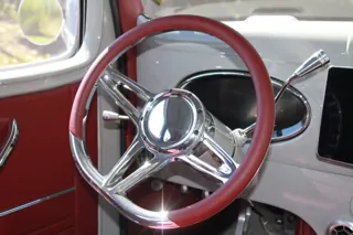 Polished three-spoke steering wheel with a red rim and the dashboard behind it — photo 10 of 40