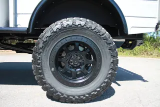 Black wheel and off-road tire beneath the rear fender — photo 28 of 40