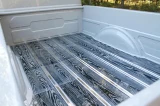 Wood-grain pickup bed with contrasting metal strips and chalk-colored bedsides — photo 36 of 40