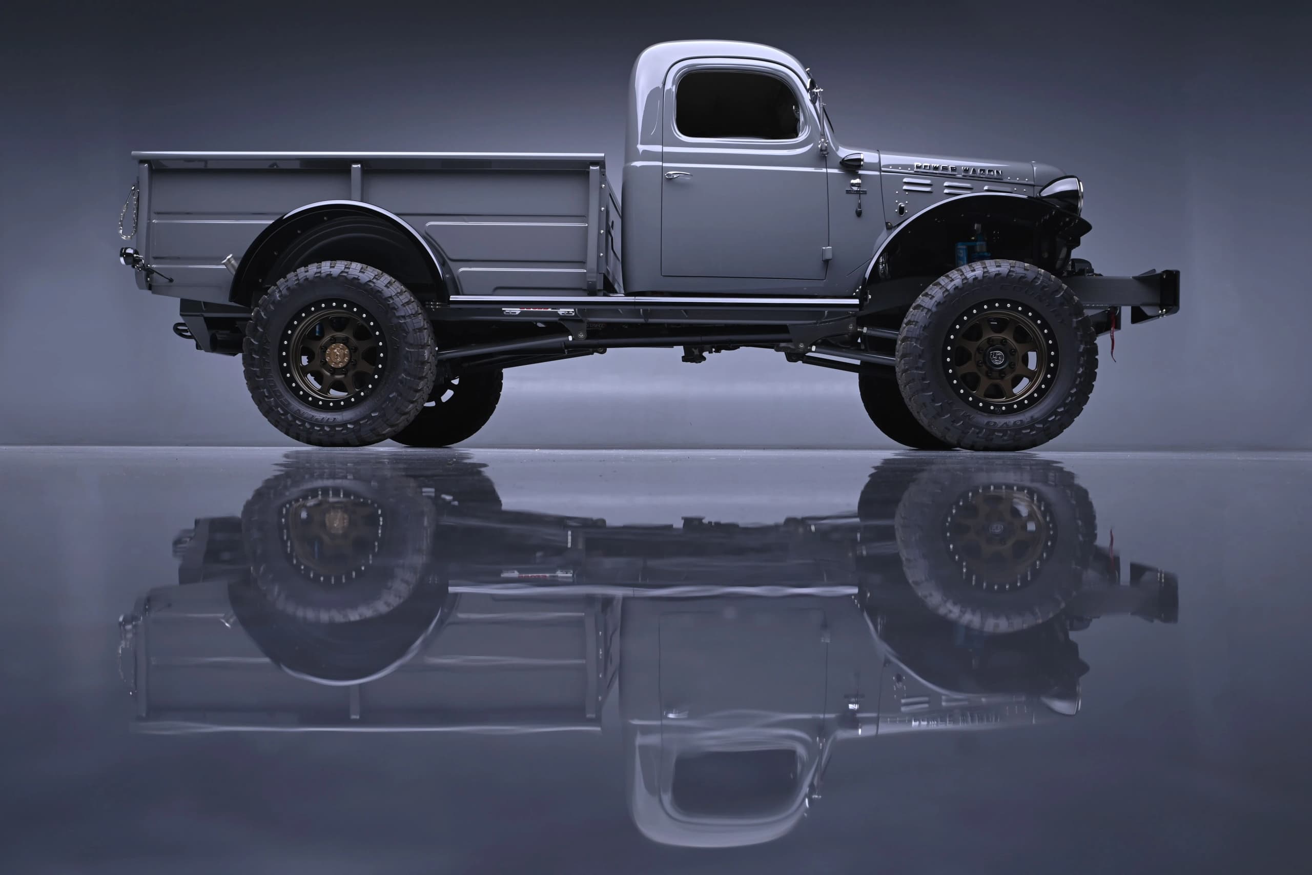 Full side profile of the gray Power Wagon reflected on the studio floor — photo 4 of 8